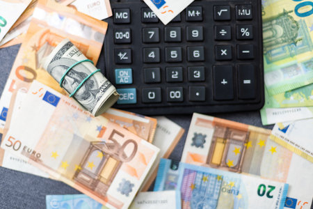 Euro and dollar notes. euro against dollar. A closer look of the president of the USA with a dollar bill, peeping out from behind a euro bill. USA and Europe finance relation. Close up top view.の写真素材