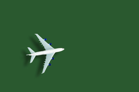 Airplane model. White plane on green background. Travel vacation concept. Summer background. Flat lay, top view, copy space.の写真素材