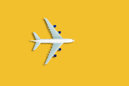 Flat lay design of travel concept with plane on yellow background with copy space.の写真素材