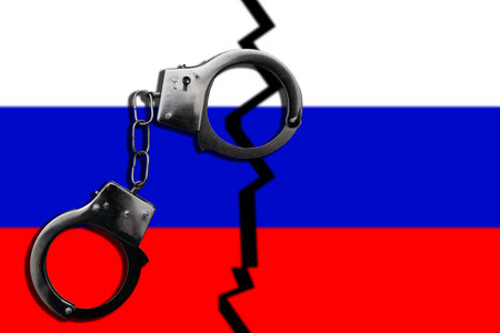 The concept of law and crime. There are handcuffs on the flag of Russia.の写真素材