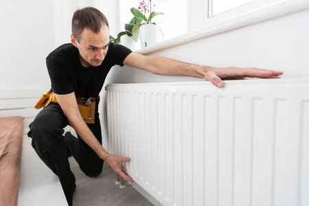 Repair heating radiator close-up. man repairing radiator with wrench. Removing air from the radiatorの写真素材
