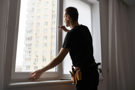 Worker adjusting installed window with screwdriver indoors, closeupの写真素材