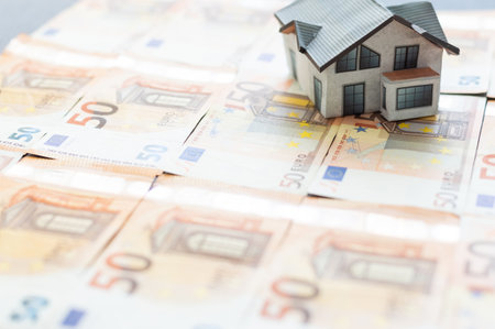 Euro banknotes laying under model homeの写真素材