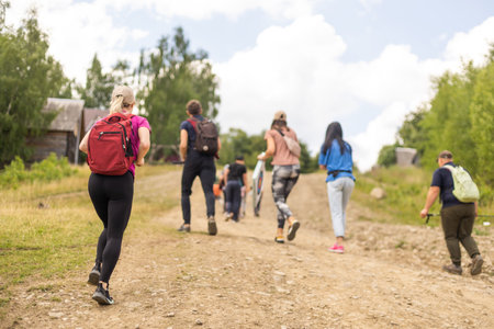 Group of hikers with backpacks climbing up mountainsの写真素材
