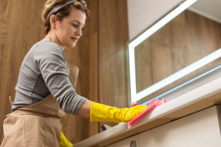 Housemaid cleaning a bathroom, closeup shotの写真素材