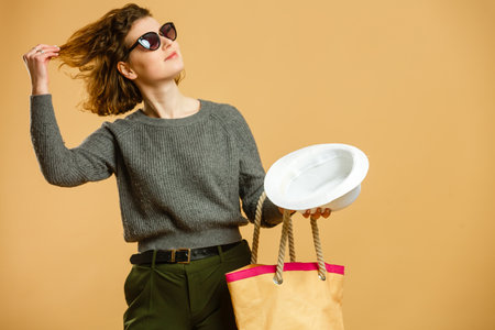 concept of travel. happy woman girl with suitcase and passport on yellow colored background.の写真素材
