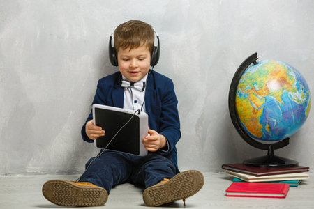Cute little schoolboy on gray background with space for text