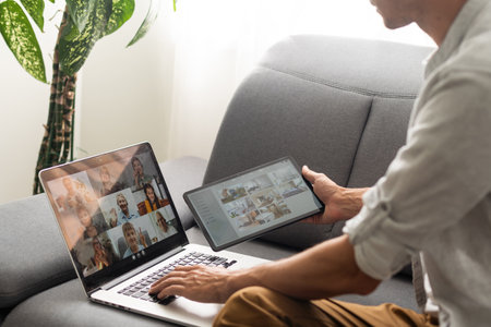 Image of Young man working in front of the laptop looking at screen with a clean white screen and blank space for text and hand typing information on keyboard in modern workspaceの写真素材