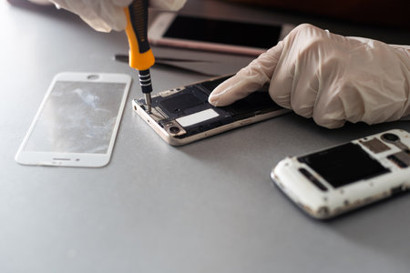 The technician repairing the smartphones motherboard in the lab with copy space. the concept of computer hardware, mobile phone, electronic, repairing, upgrade and technology.の写真素材
