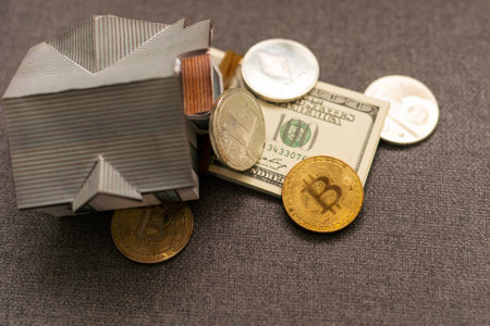 Toy house and coins bitcoin on black background. Cryptocurrency and saving concept. Electronic virtual money for web banking and international network payment.の写真素材
