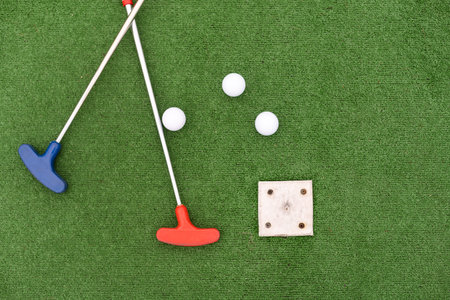 colorful golf putters with golf balls on synthetic grass