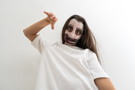 portrait of teenage girl with skull makeup on face.の写真素材