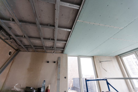 Man assembles profile metal frame for plasterboard ceilings