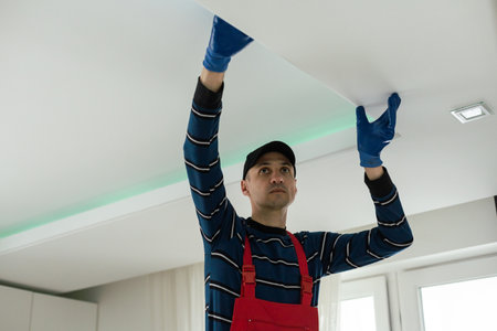 An electrician is installing LED spotlights on the ceiling.の写真素材