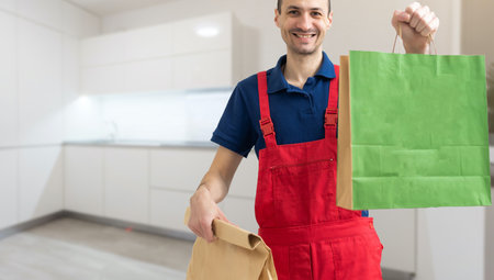 Courier holding paper bags with food, space for text. Delivery serviceの写真素材