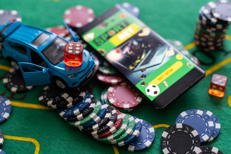pile of casino chips and toy car, smartphone with betting on sportsの写真素材