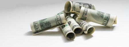 roles dollar notes in front of white background