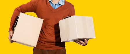 young delivery man standing with parcel post box