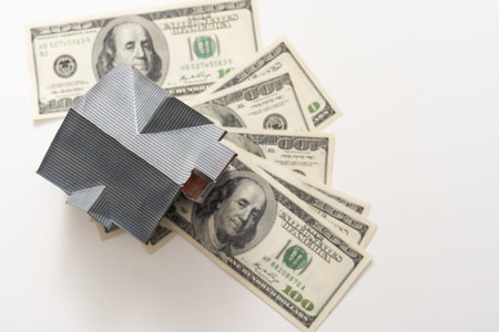a toy house with banknotes, home insurance, mortgage, a symbol of material well-being