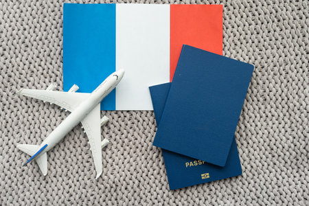 Flag of France with passport and toy airplane on wooden background. Flight travel concept.の写真素材