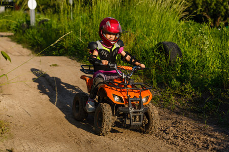 A child rides a quad bike through the mud. ATV rider rides