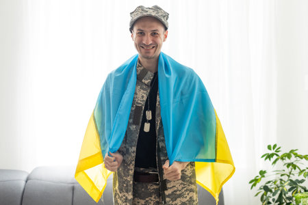 Portrait of a courageous Ukrainian military man holding the flag of Ukraine, freedom concept.