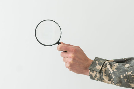 soldier holding magnifying glass in officeの写真素材