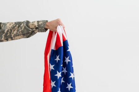 american military soldier holding flag. male officer in camouflage uniform. Concept of military,...