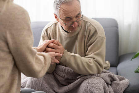 Young woman holding senior man hands, closeupの写真素材