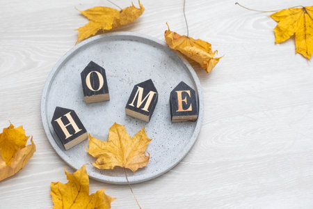 Yellow leaves on a light background with the inscription home.の写真素材