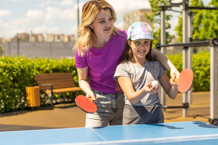 Happy Mother and Daughter Learning to Play table tennis Sport Cheerful family playing leisure sports enjoying table tennisの写真素材
