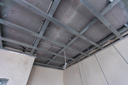 Workers assemble a suspended ceiling with drywall