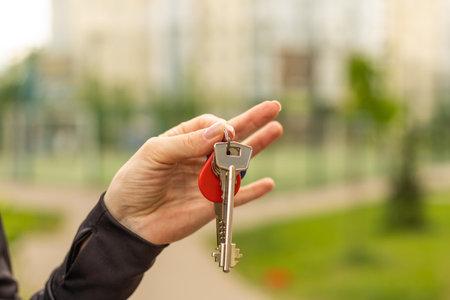 Hand holding keys, realtor, buildingの写真素材