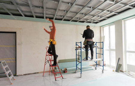 Builder fastens profile using cordless screwdriverの写真素材