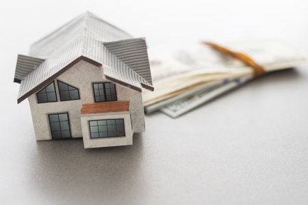 Wooden house model on background of US dollars banknotes. Housing market, purchase or rental of real estate. The concept of buying and selling real estateの写真素材