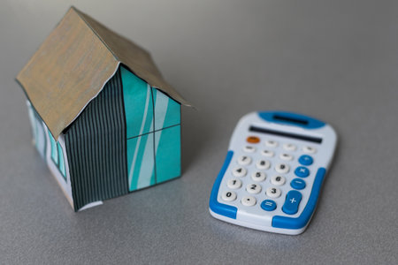House is placed on the calculator. Imagine calculating to buy a home. planning savings money to buy a home concept for property, mortgage and real estate investment. to buy a house.の写真素材