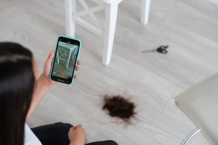 Black hair after a haircut on a white background with scissorsの写真素材