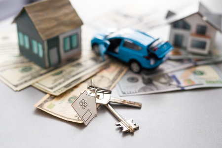 House model and car, laptop contract document on table, real estate business concept.