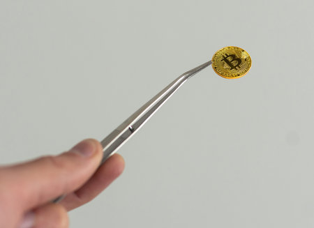 bitcoin and tweezers in the hand.の写真素材