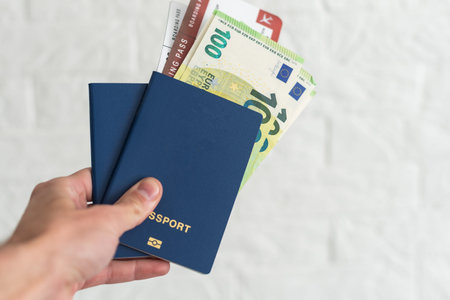hands holding passport and several banknotes