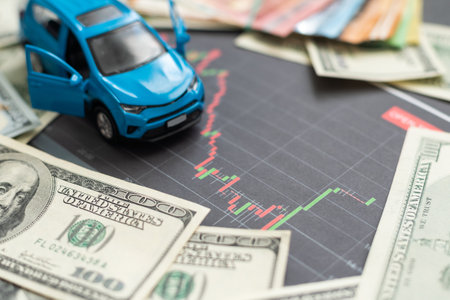 Coins stacking on the bank notes in front of the carの写真素材