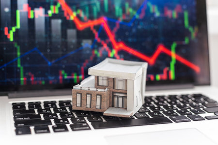house model in a grocery cart on the background of a laptop. buying real estate online.