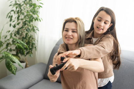 Mother and daughter playing video games on laptop at home.の写真素材