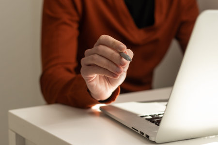 Businessman hand holding pen working on laptop computer, working online concept, e business concept