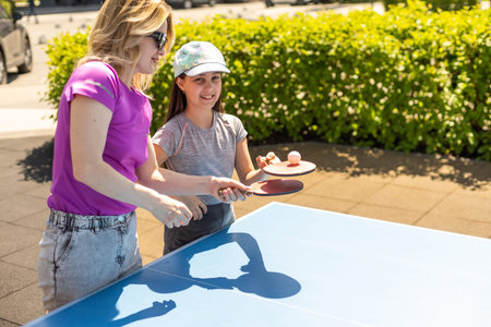 Happy Mother and Daughter Learning to Play table tennisの写真素材