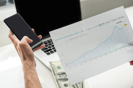 data analyzing in stock market: on the charts and quotes prints, the smart phone, eyeglasses and a...