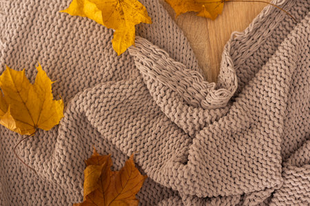 Autumn background with a plaid and with yellow leavesの写真素材