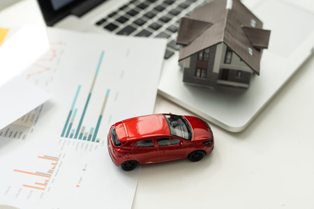 flat lay toy car, toy house, keys and money on the tableの写真素材