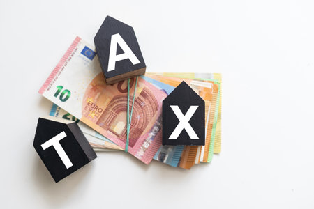 Tax text in wooden cubes and tax or vat form documents to complete Individual income tax return form for payment to Government. Calculation tax return in 2022 to 2023.の写真素材