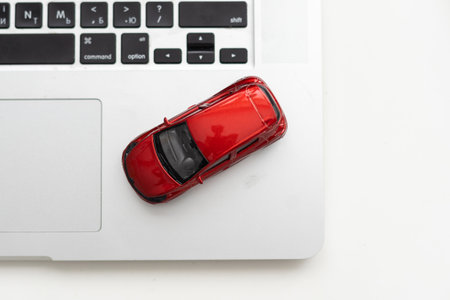 Car model on notebook and mouse on wooden desk. About car business concept such as transportation, rental, sell and buyの写真素材